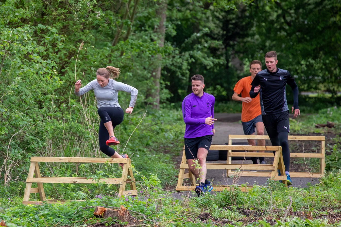 Mensen doen aan hordelopen in het stadspark van Kampen